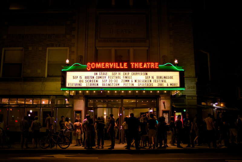 Following the end of a film showing, audience are exiting the theater.