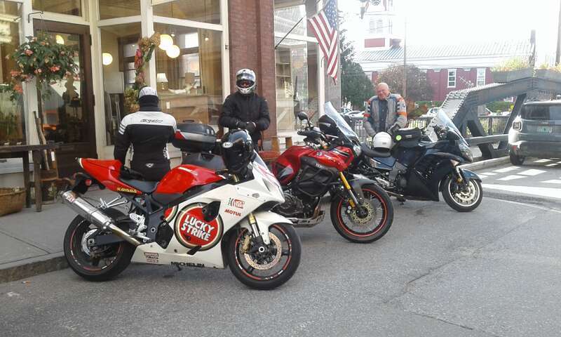 Three motorcycles with riders from Quebec parked on Langdon Street in downtown Montpelier, Vermont.