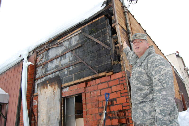 W.Va. Army National Guard Staff Sgt. Christopher Hamrick, the CBRNE non-commissioned officer assigned to CERFP in Eleanor, points out the structural damage incured to a gas station in Summersville, W.Va. after Hurricane Sandy dropped two feet of snow