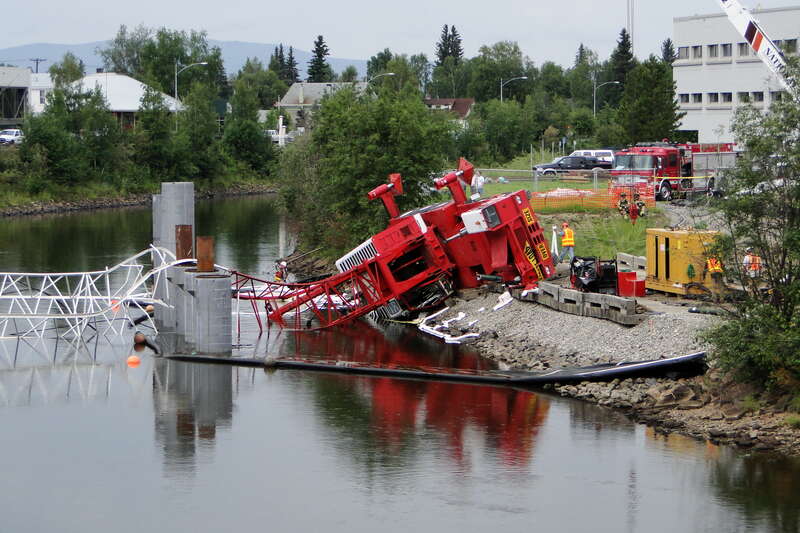 The crane working on the ill-conceived Barnette Street Bridge in downtown Fairbanks takes a tumble down the riverbank.