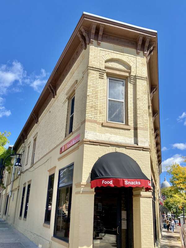 Built in 1889 and expanded in 1896, this Italianate-style flatiron building at 346 State Street in Madison, Wisconsin, was constructed for Henry Schulkamp.  The building features a partially painted buff brick exterior, replacement one-over-one