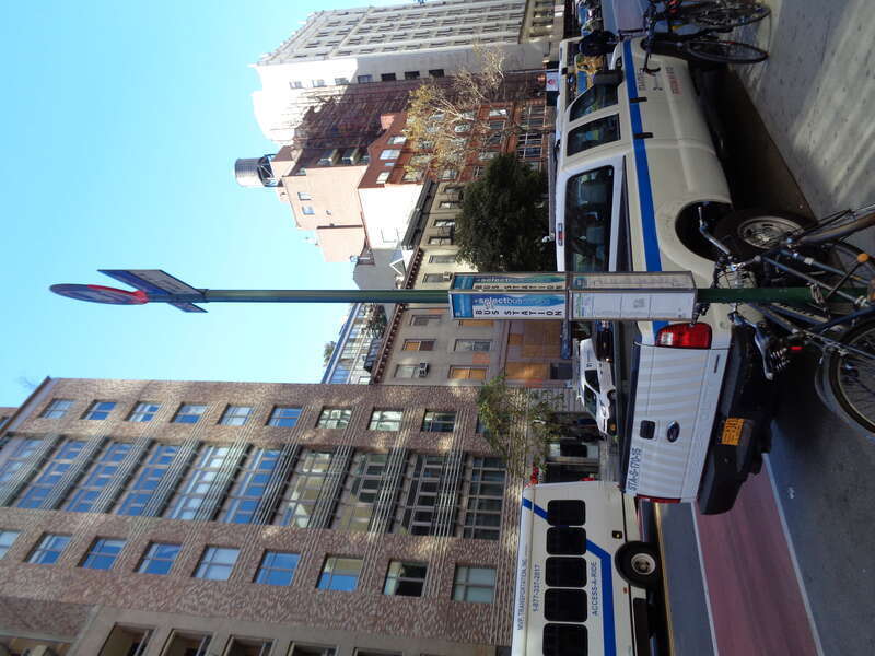 A stop for westbound (Chelsea-bound) M23 SBS buses at 23rd Street between 6th Avenue and 7th Avenue in Chelsea, Manhattan. The stop is listed as West 23rd Street and 6th Avenue.