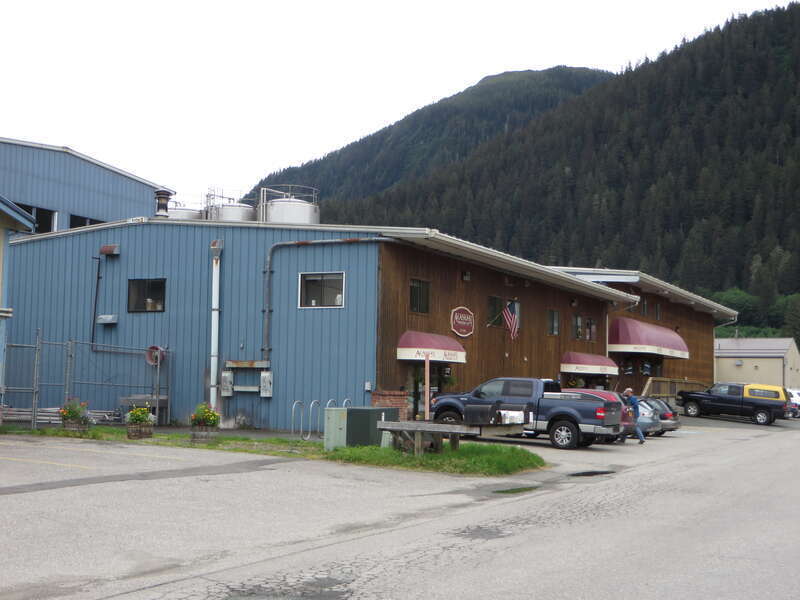 Cars parked outside the taproom of Alaskan Brewing Company on Shaune Dr in Lemon Creek, Juneau. Notice the tall outdoor storage tanks over the roof.

Alaskan Brewing Company was founded in 1986 by Marcy and Geoff Larson, who are still in charge of