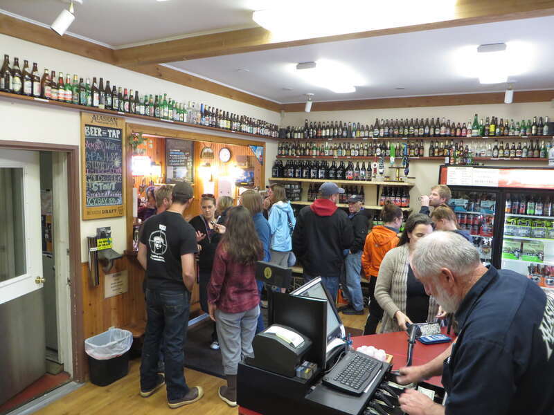 Visitors standing in front of the bar at the taproom of Alaskan Brewing Company in Juneau, Alaska. The taproom is also a shop where visitors can by various effects in addition to all the different Alaskan beers.