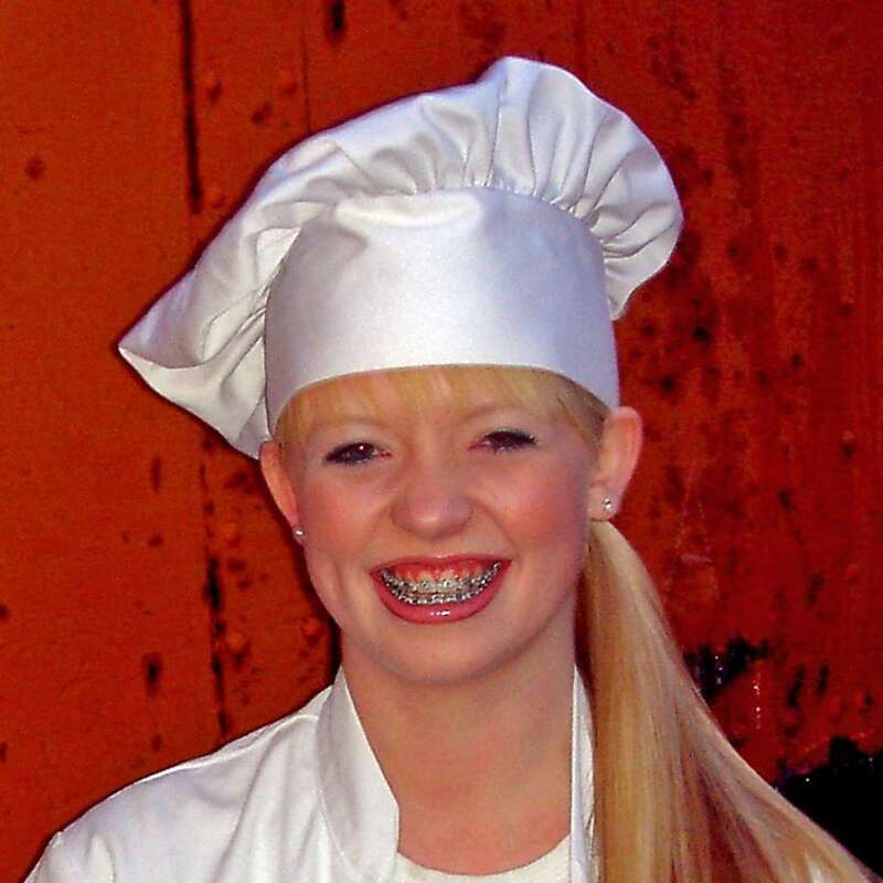 Young woman wearing a traditional chef's uniform