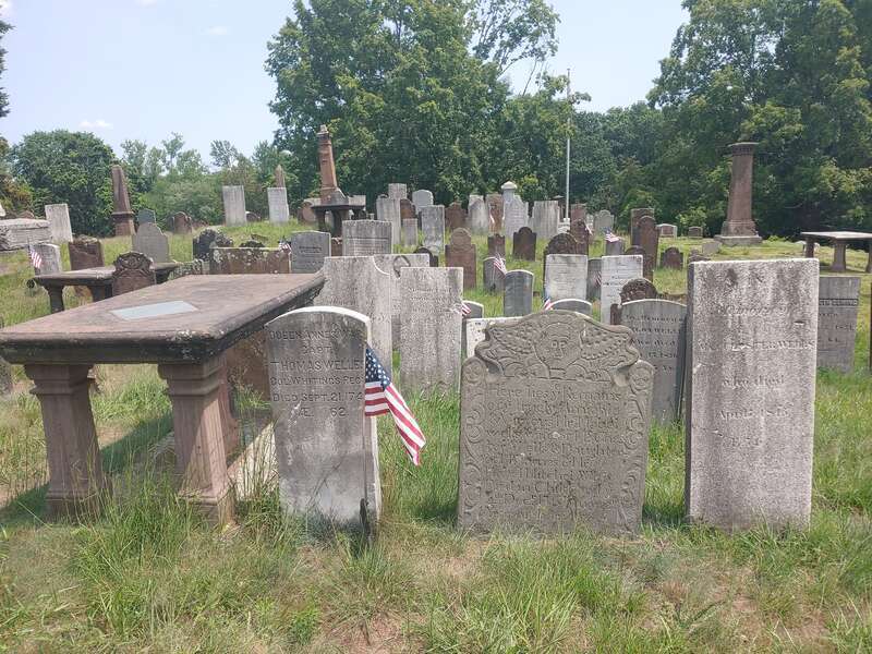 View of brown table markers and gravestones in the Wethersfield Village Cemetery