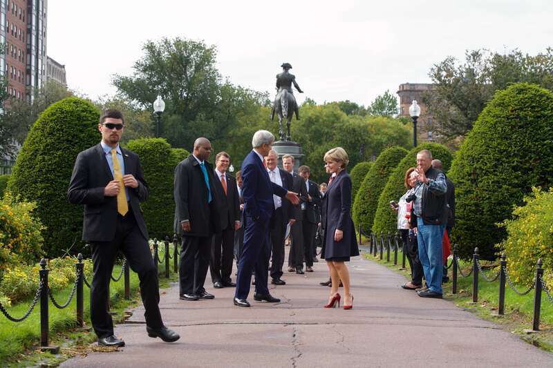 U.S. Secretary of State John Kerry waves goodbye to a group of tourists who said hello as he escorted Australian Foreign Minister Julie Bishop through the Boston Public Garden on October 13, 2014, after he and U.S. Defense Secretary Ash Carter held