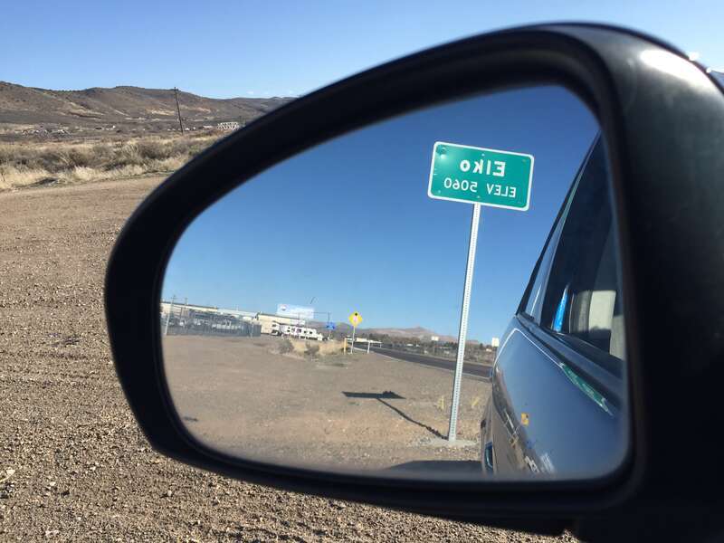 Entering &quot;Elko, 5060&quot; feet above sea level sign reflected in a side rear-view mirror on Idaho Street (Nevada State Route 535 and Interstate 80 Business) in Elko, Nevada