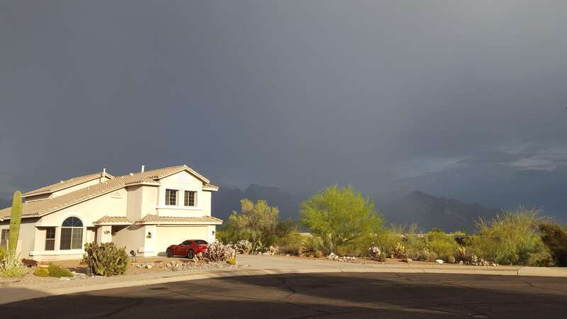 A photo of a house in Oro Valley, Arizona, with a rain storm going on behind it, in July 2022.