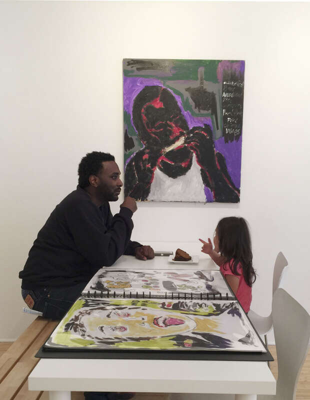 Artist John Isiah Walton in front of one of his paintings.
