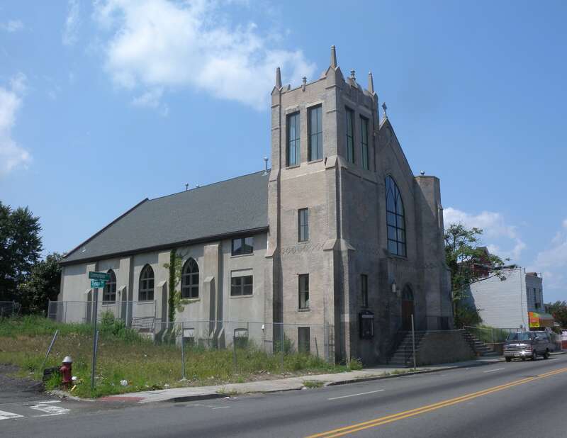 Looking west along Communipaw Avenue (County Route 612) at Clair Memorial United Methodist Church and distant JFK Blvd on a sunny midday.  Building is little used since they started meeting at Temple Bethel, north of here on the Boulevard.