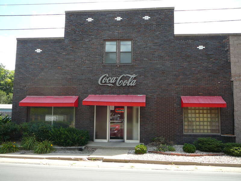 A photo of the front entrance to the Coca-Cola Bottling Co of Macomb, a Coke distributor located in Macomb, IL 61455, taken from across the street on the west side of South Johnson