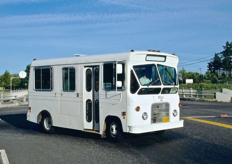 TriMet minibus No. 69, a &quot;Flxette&quot; model (manufactured by the Flxible Company), in service on a short-lived, unnumbered TriMet route between the Cedar Hills Transit Center and the Oregon Graduate Center, via Tanasbourne Mall.  The minibus is turning