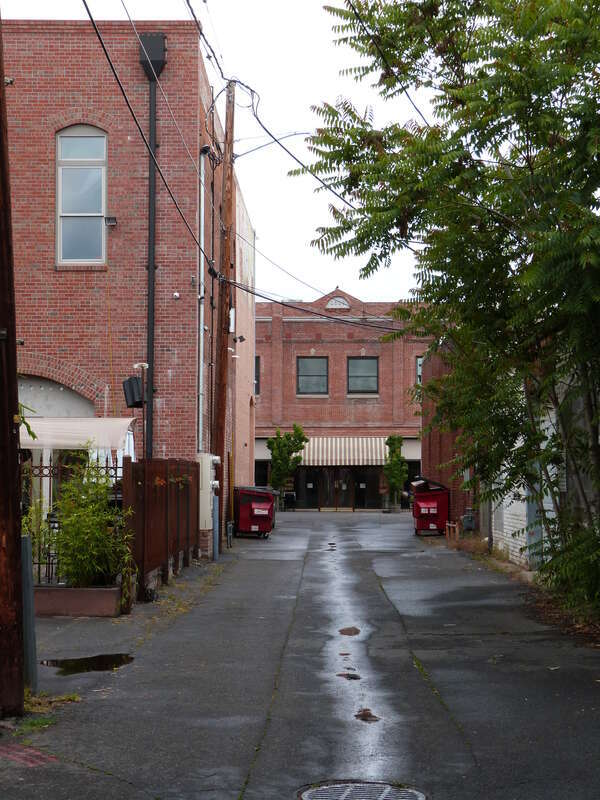 The alley between South Grape and Fir Streets, on the block between West Main and 8th Streets, in Medford, Oregon, United States, looking toward Main Street. Across Main Street at the end of the alley is the historic Weeks and Orr Furniture Building