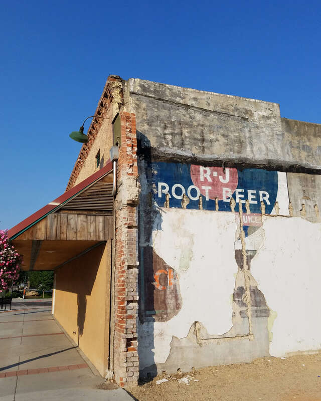 The Hires R-J Root Beer ghost sign in Caldwell, Idaho, partially had been protected from weather until a 1990 fire destroyed the nearby Saratoga Hotel and the adjacent building, then demolition of buildings in the block revealed what was left of the