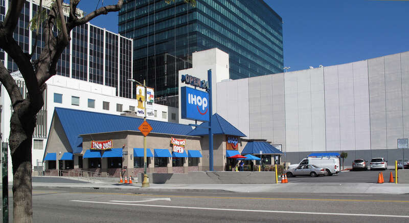 IHOP with Takeout signs during Coronavirus lockdown April 2020. Patrons are visible waiting for their to-go orders. Wilshire Center, Los Angeles, on 6th St. just east of Vermont.