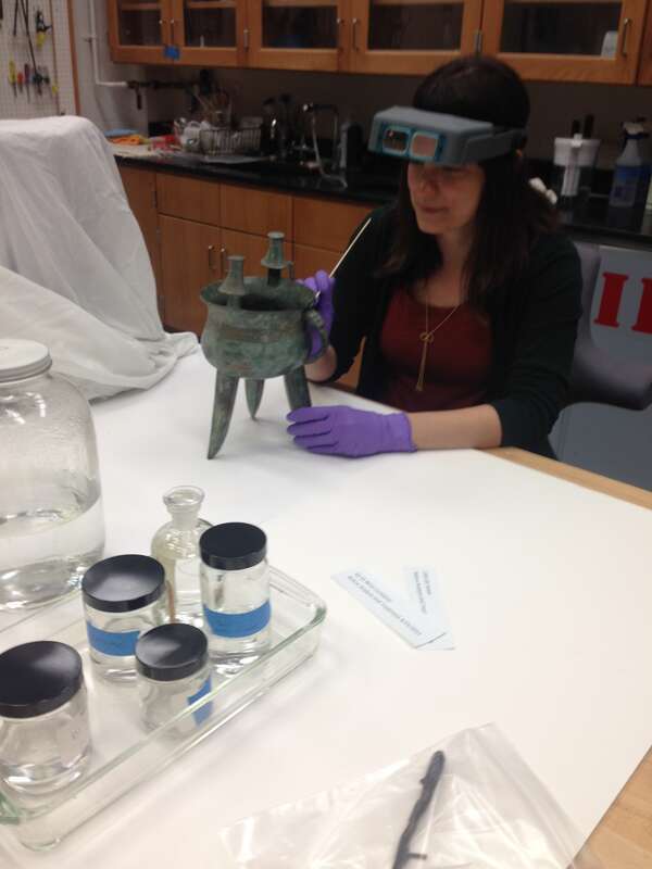 IMA Objects conservator examines a Chinese vessel.