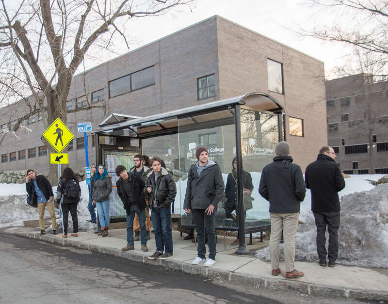 People waiting at bus stop in Purchase, New York, moments before the bus arrives.