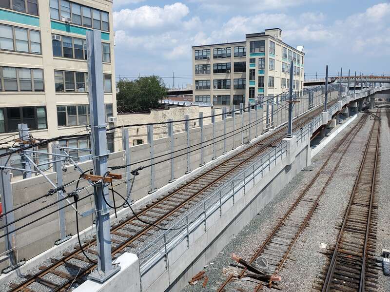 Red Bridge viaduct under construction in July 2021. At left is the inbound track from Union Square; to its right are a commuter rail siding track and one track of the Fitchburg Line.