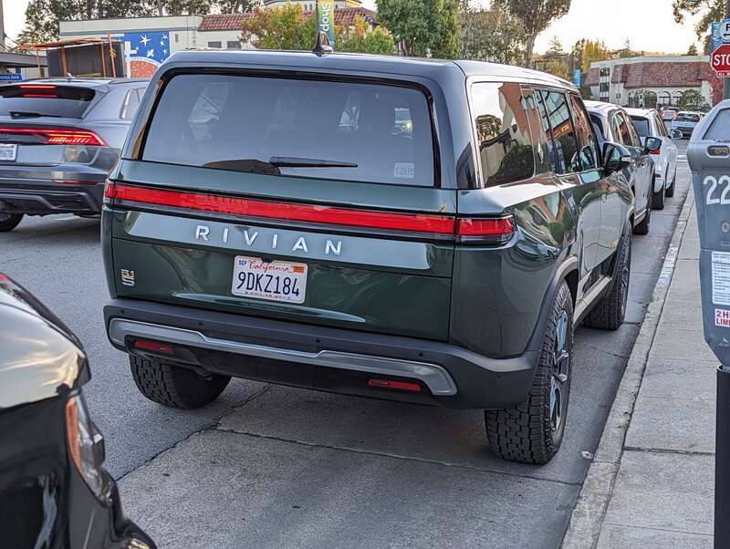 Rivian R1S sport utility vehicle in a dark green color, parked on Howard Avenue in Burlingame California