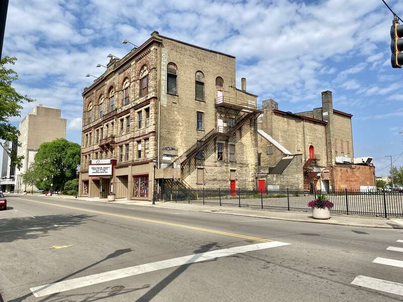 Built in 1890, this Richardsonian Romanesque Revival-style building was designed by Samuel Hannaford for Paul J. Sorg to serve as an opera house.  The building features a brick exterior with a rough-hewn stone front facade, arched window bays on the