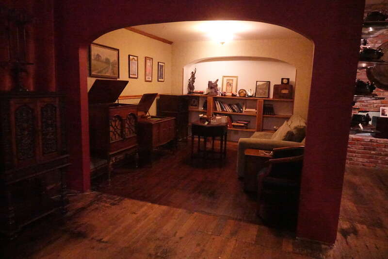 This is a 1940's living room mock up with a variety of radios. Every piece of furniture except for the chairs and the bookcase is a radio