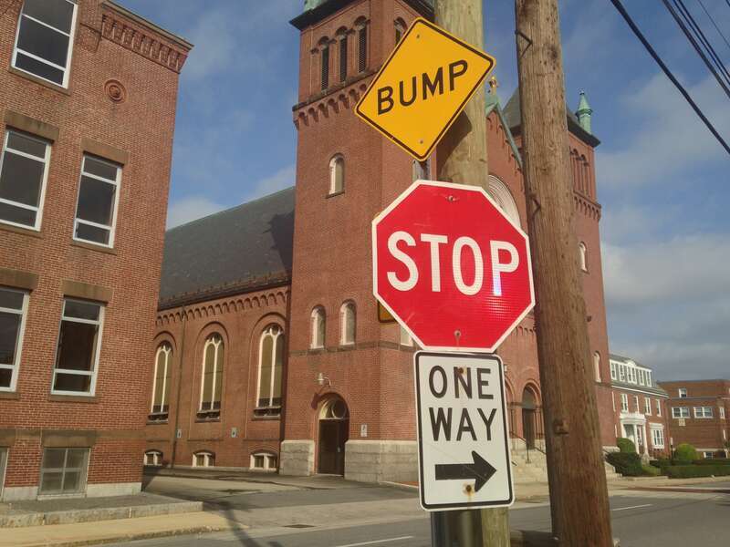 A stop sign accompanied by two other traffic control signs in Nashua, New Hampshire.