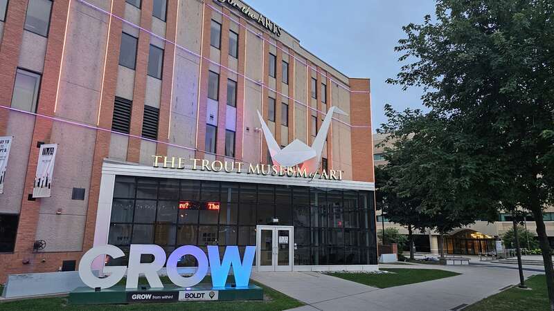 A photograph of the entrance to the Trout Museum of Art at dusk, looking from the sidewalk next to houdini plaza