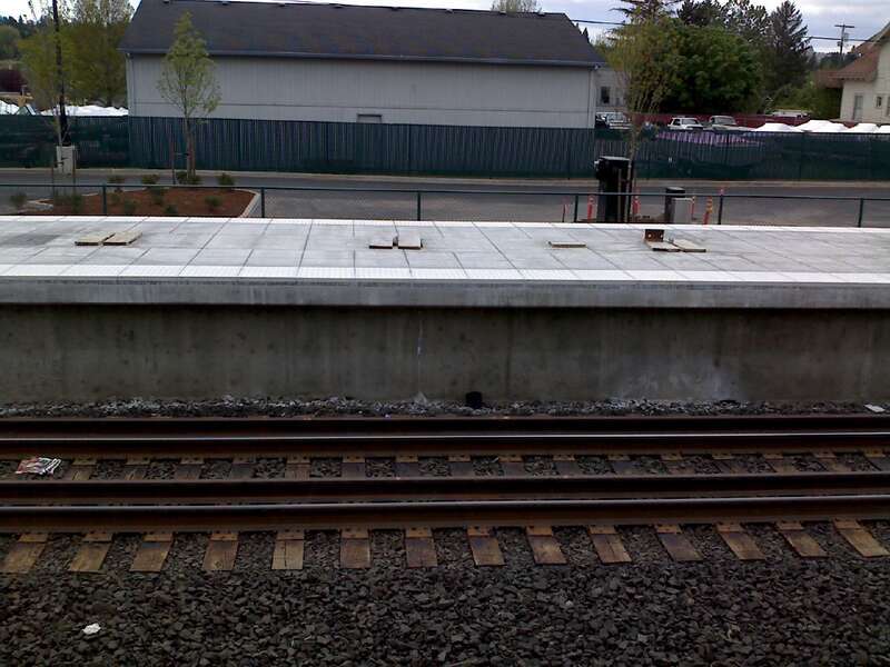 Westside Express Service commuter rail platform next to Tigard Transit Center.  Note the gauntlet track that allows passenger trains to get close to the platform while allowing good clearance for freight trains.