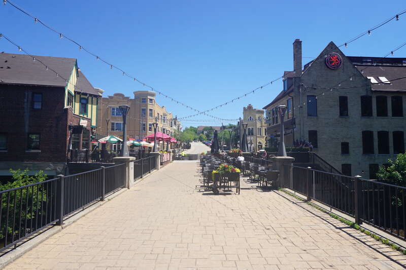 A pedestrian bridge and the Buckatabon and Café Hollander patio in Wauwatosa, Wisconsin (United States).