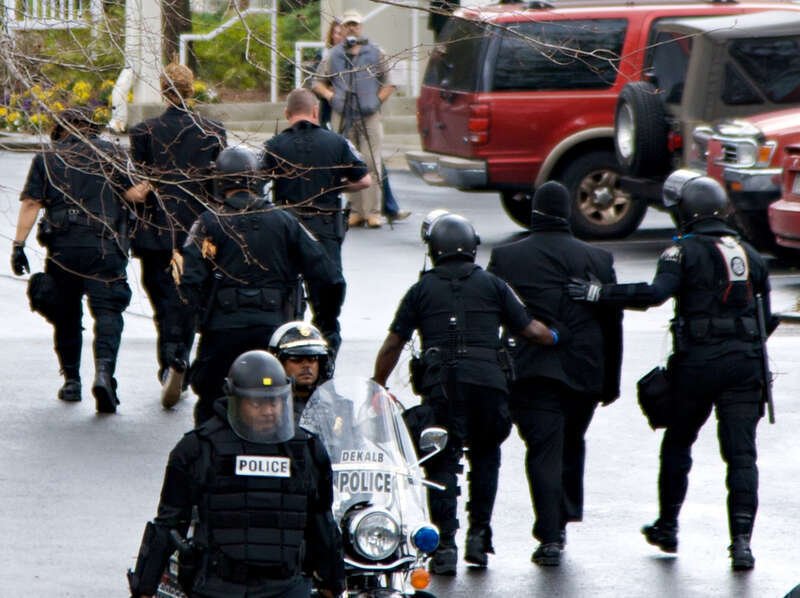 Protester being led away by police at anti-Scientology protest in Atlanta, GA