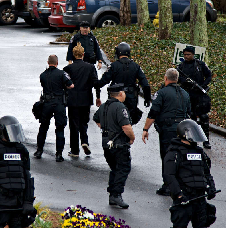 Protester being led away by police at anti-Scientology protest in Atlanta, GA