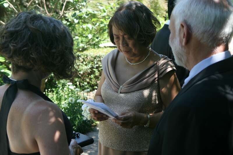 A wedding guest reading an informational sheet at a wedding held at the J. C. Raulston Arboretum in Raleigh, North Carolina.