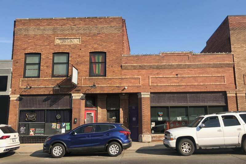 The east block (5916) rises one story while the west block (5918) rises two stories. Brick cladding and decorative elements unify the blocks.