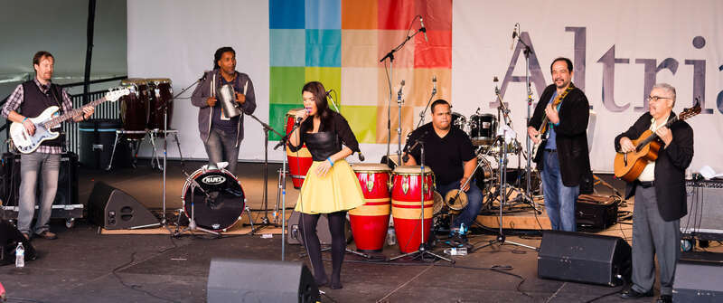 Richmond Folk Festival 2015
Andre Veloz (center) is a singer from the Dominican Republic based in New York City.  Her musical specialty is &quot;bachata,&quot; a style originating in the Dominican Republic and first recorded in the 1960s. Historically