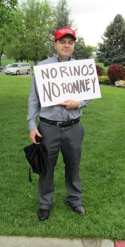 Protester at a Mitt Romney senate campaign rally with the sign &quot;No RINOS No Romney&quot;.