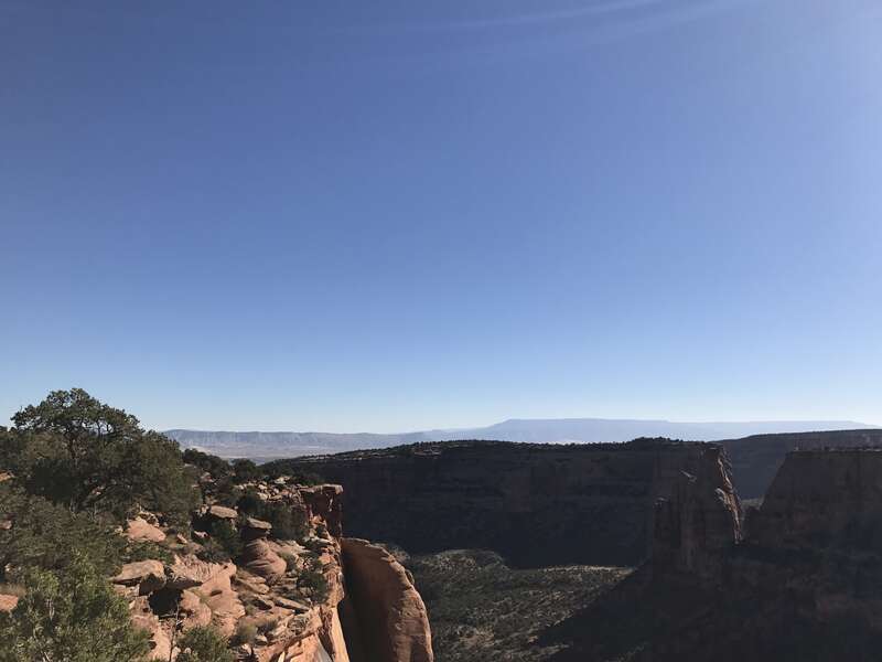 This is a picture taken behind the visitor's center at the Colorado National Monument. You can see the large straiated rocks in the foreground as well as the San Juan mountain range peaking out in the background.