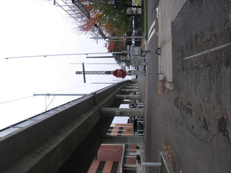 Looking east at the intersection of 21st and R Streets in Sacramento, California, USA.  This is the site of a former rail line (tracks are visible in the pavement) but the Sacramento RTD light rail Gold Line (Sacramento RT) is carried by the overhead