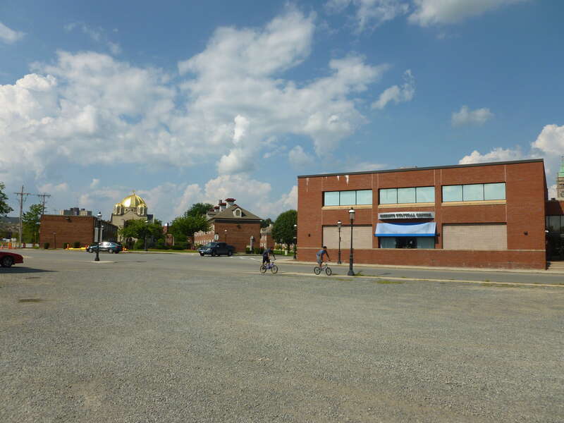 Looking north near the intersection of Broadway Street and Dummer Street in Lowell, Massachusetts.  The Hellenic Cultural Center is visible at left; at right, the Greek Orthodox Holy Trinity Church.