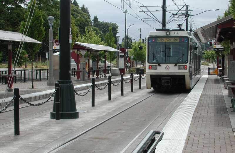 A train waits at the Kenton/North Denver Avenue station of the Metropolitan Area Express (MAX) light-rail system in Portland, Oregon, United States. View is to the north.