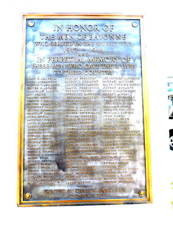 Looking southeast at honor role plaque for The World War on a sunny morning.