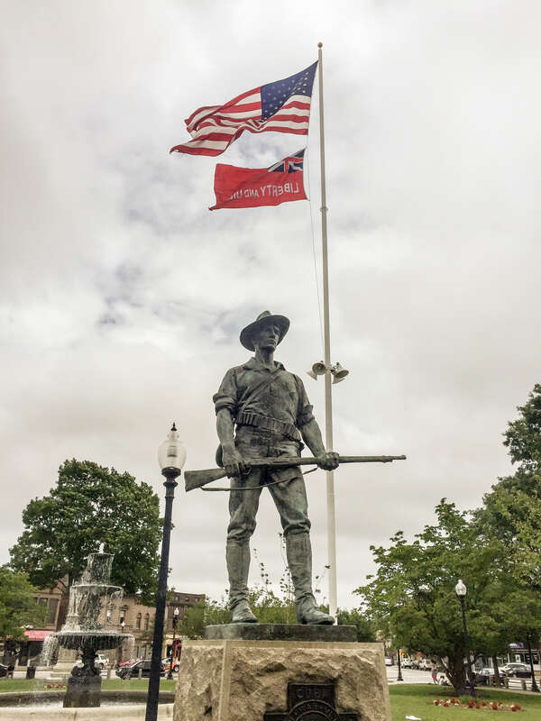 Kitson's The Hiker stands over Taunton Green, Massachusetts as the Taunton Flag flies overhead.