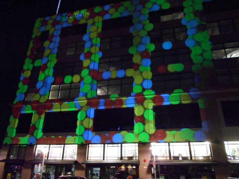 Laser projections from Spark Museum to side of Faithlife Building at Downtown Bellingham Art Walk