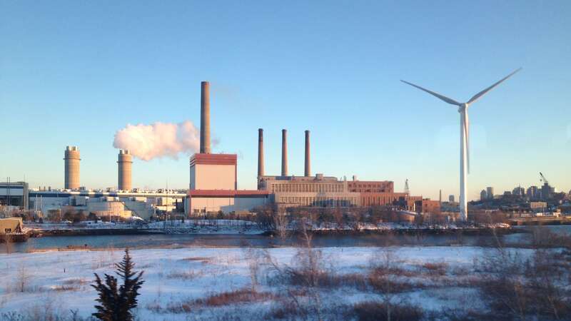 Mystic Generating Station, on the Mystic River in Everett, Massachusetts, a gas and oil-fired power plant. Also shown is a wind turbine which is not part of the power plant, but owned by the water authority to power a pumping station.