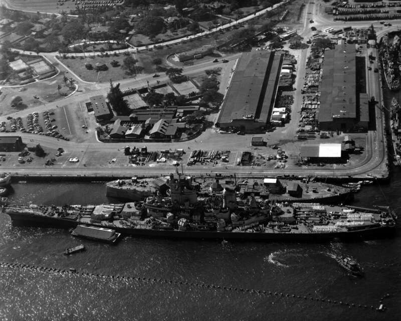 Tied up outboard of the hulk of USS Oklahoma (BB-37), at the Pearl Harbor Navy Yard, 11 November 1944. Note: anti-torpedo netting outboard of the ships; great difference in lengths of these two battleships.  U.S. Naval History and Heritage Command