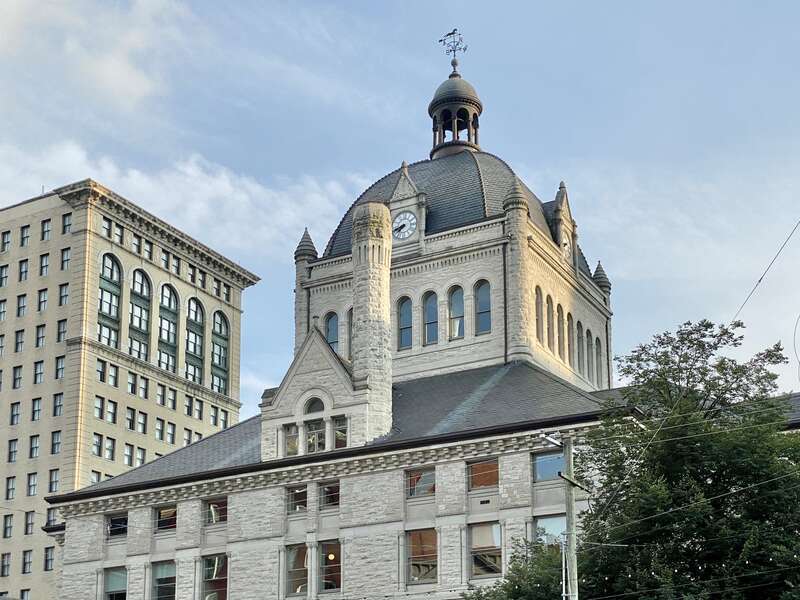 On the left, built in 1898-1900, this Richardsonian Romanesque Revival-style building was designed by Lehman and Schmitt to serve as the Fayette County Courthouse, and is the fifth courthouse to serve Fayette County, replacing a previous courthouse,
