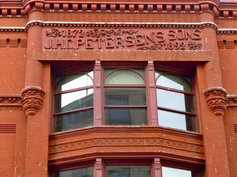 Window above main door of J.H.C. Petersen's Sons' Store, on the NRHP since July 7, 1983. At 123-131 W. 2nd St., Davenport, Scott County, Iowa.
Former department store building built in the Romanesque Revival style in 1892. The structure continues to
