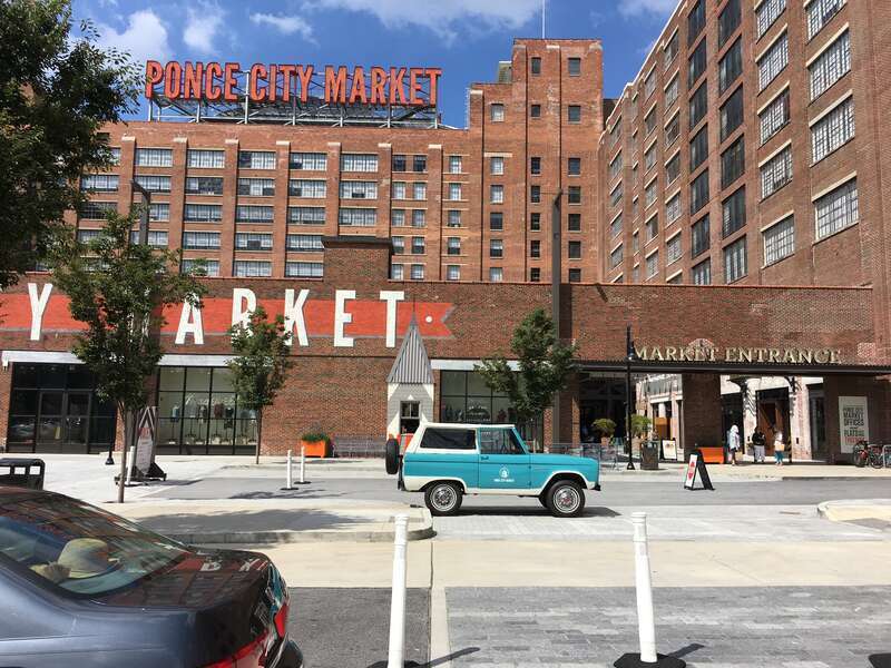 The front of the Ponce City Market showing the large neon sign on the rooftop in Midtown, Atlanta, GA. The building, originally built in 1926, was renovated into a mixed-use complex that opened in 2014.