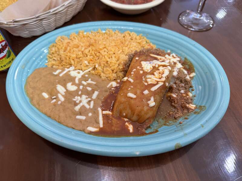 Pork tamale topped with red enchilada sauce and ground beef with a side of refried beans and rice Puerto Vallarta, Greenwood, Indiana