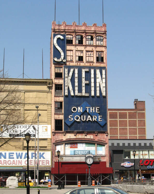 Looking west across Broad Street at en:S. Klein On the Square from, Military Park in en:Downtown Newark, sunny noon in springtime.